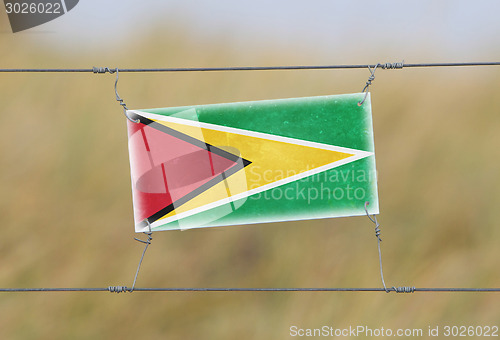 Image of Border fence - Old plastic sign with a flag