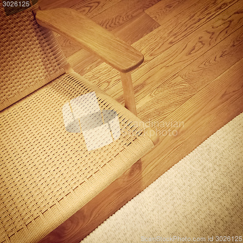 Image of Rattan chair and rug on wooden floor