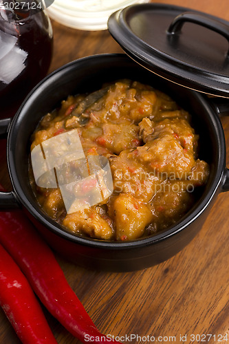 Image of homemade hot goulash on wooden table