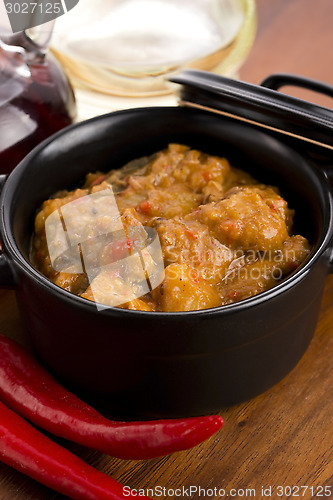 Image of homemade hot goulash on wooden table