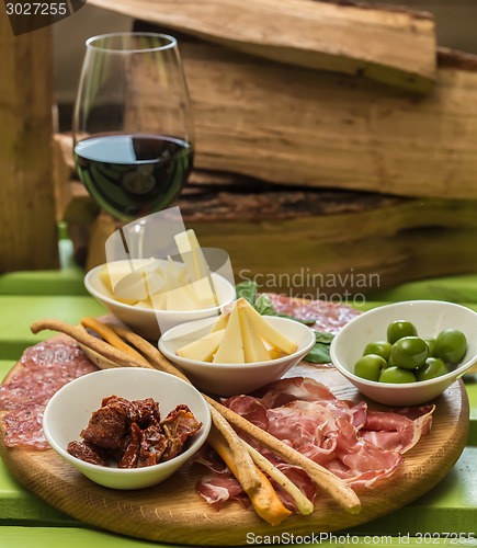 Image of different italian antipasti and red wine