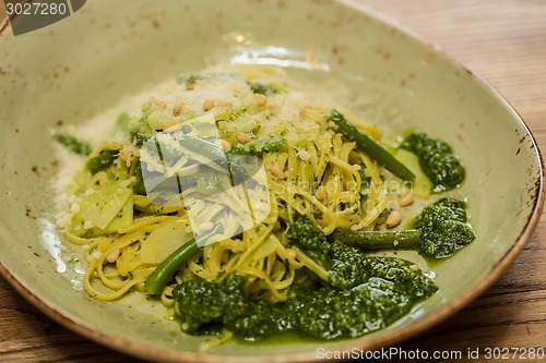 Image of Italian pasta with pesto sauce close-up.