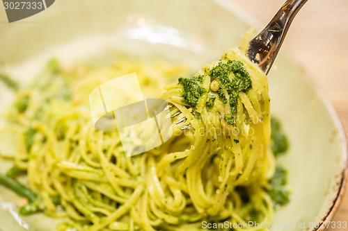 Image of Italian pasta with pesto sauce close-up.