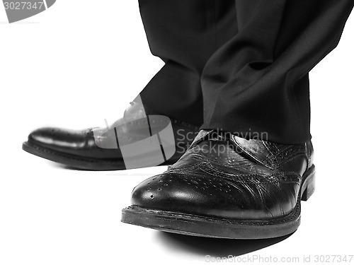 Image of Masculine suit wearing black shoes towards white