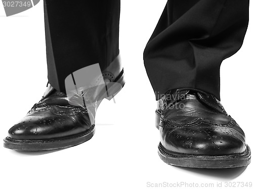 Image of Masculine suit wearing black shoes approaching towards white