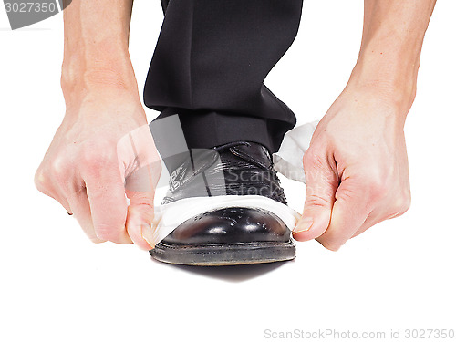 Image of Closeup of male shining black leather shoes with a sheet of whit