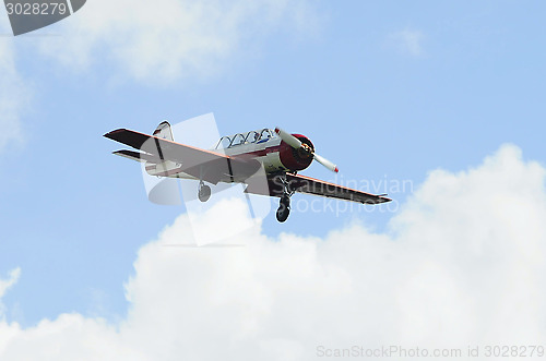 Image of The small plane flies against clouds.