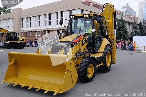 Image of The yellow bulldozer is on the square in the city.