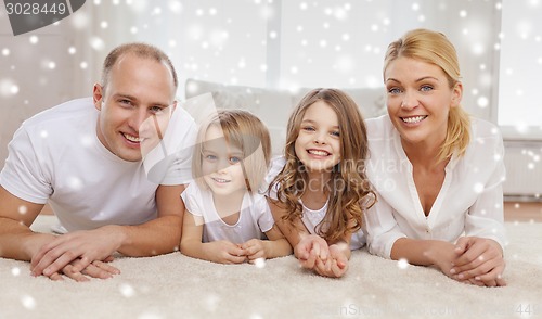 Image of smiling parents and two little girls at home