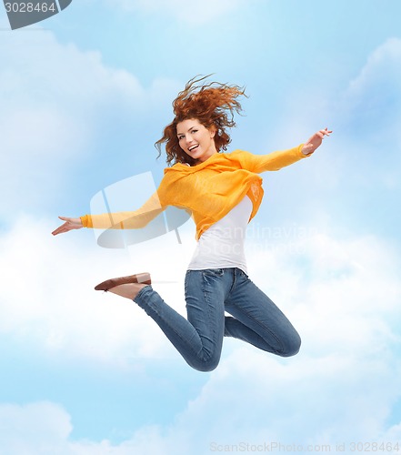 Image of smiling young woman jumping high in air