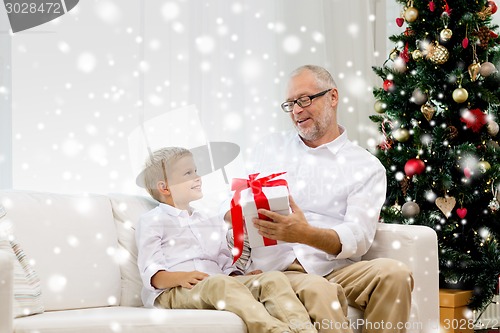 Image of smiling grandfather and grandson at home