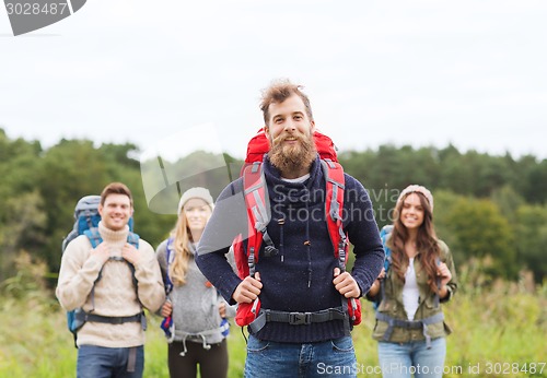 Image of group of smiling friends with backpacks hiking