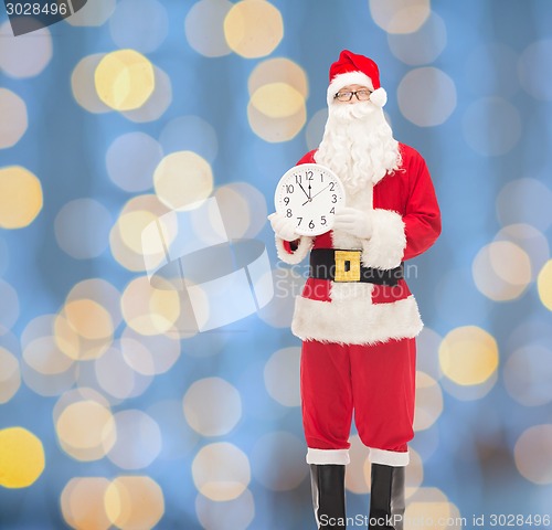 Image of man in costume of santa claus with clock