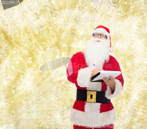Image of man in costume of santa claus with notepad