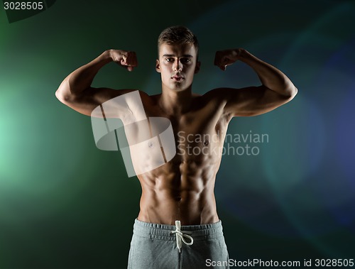 Image of young man showing biceps and muscles