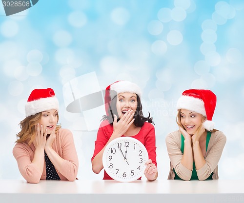 Image of smiling women in santa helper hats with clock