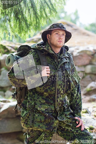 Image of young soldier with backpack in forest