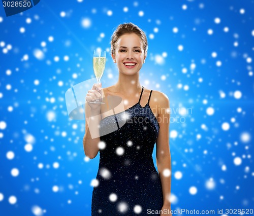 Image of smiling woman holding glass of sparkling wine