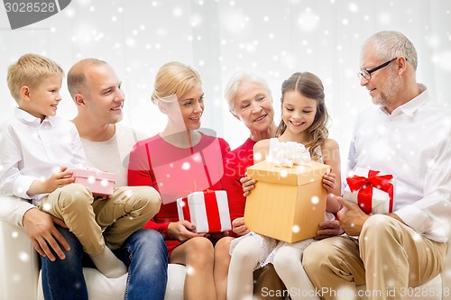 Image of smiling family with gifts at home