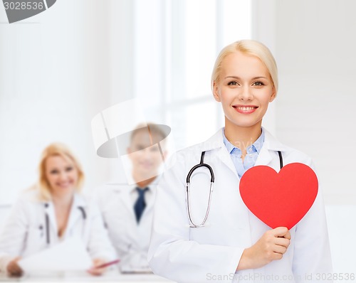 Image of smiling female doctor with heart and stethoscope