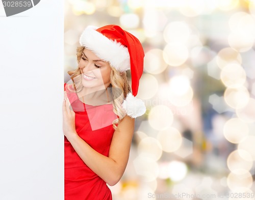 Image of smiling young woman in santa hat with white board