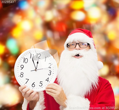 Image of man in costume of santa claus with clock