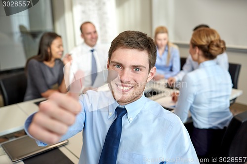 Image of group of smiling businesspeople meeting in office