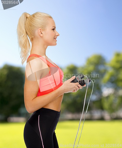 Image of smiling sporty woman with skipping rope