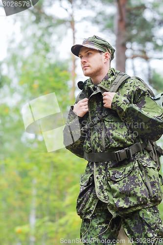 Image of young soldier with backpack in forest