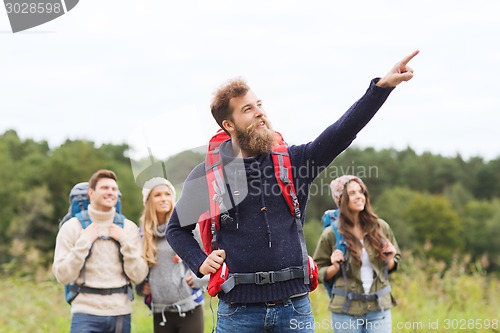 Image of smiling hikers with backpacks pointing finger