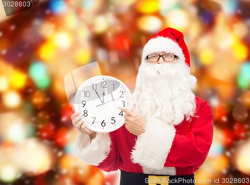 Image of man in costume of santa claus with clock