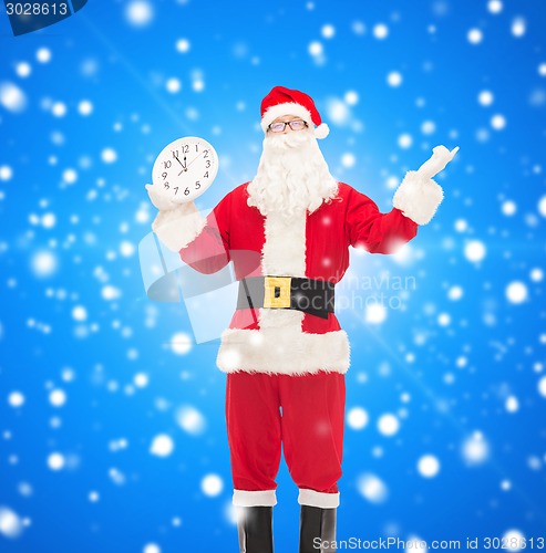 Image of man in costume of santa claus with clock