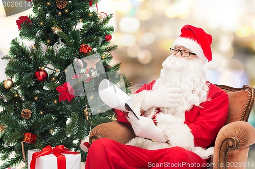 Image of man in costume of santa claus with notepad