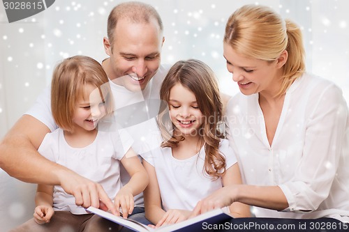 Image of happy family with book at home