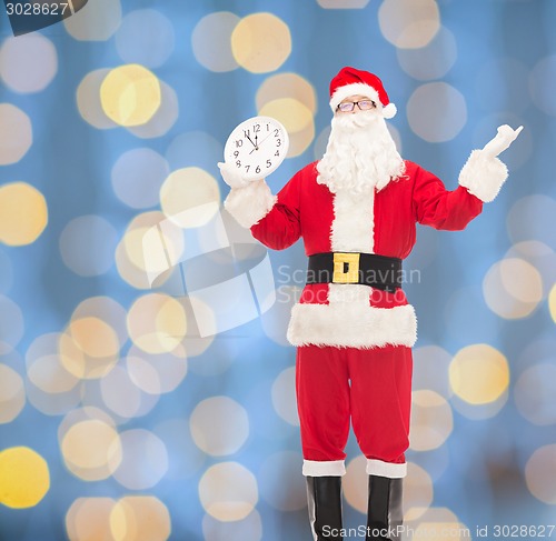 Image of man in costume of santa claus with clock