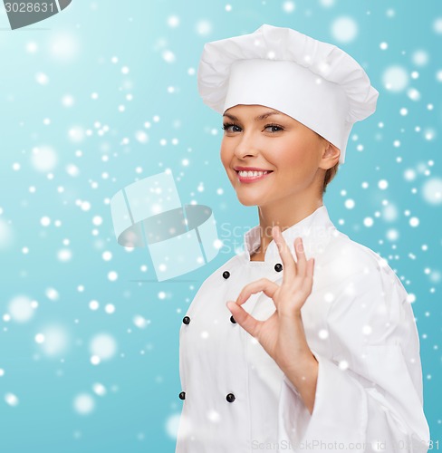 Image of smiling female chef showing ok hand sign