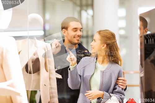 Image of happy young couple with shopping bags in mall