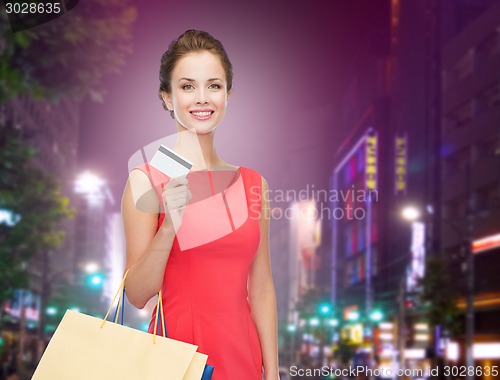 Image of smiling woman with shopping bags and credit card