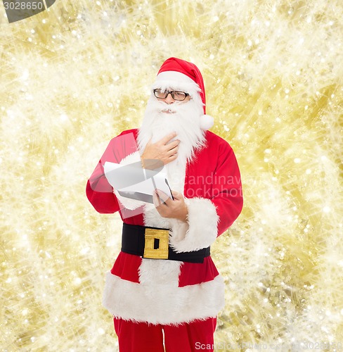 Image of man in costume of santa claus with notepad