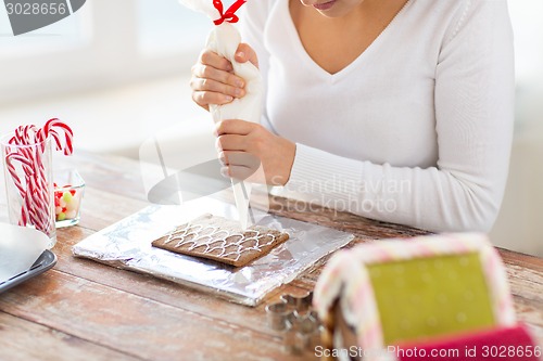 Image of close up of woman making gingerbread houses