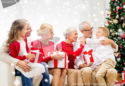 Image of smiling family with gifts at home
