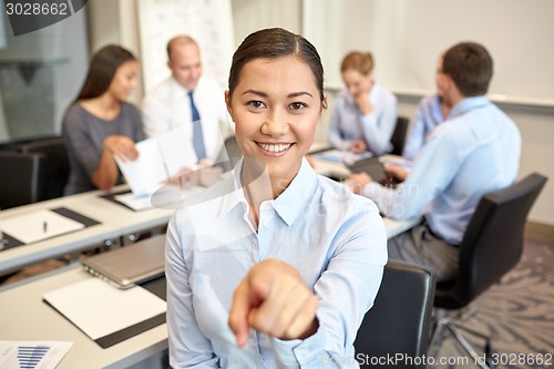 Image of group of smiling businesspeople meeting in office