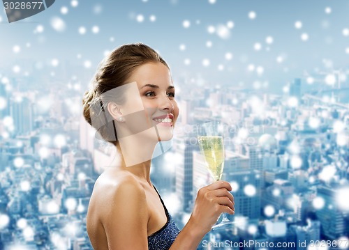 Image of smiling woman holding glass of sparkling wine