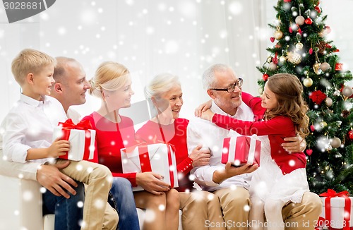 Image of smiling family with gifts at home