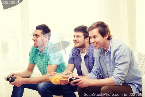 Image of smiling friends playing video games at home