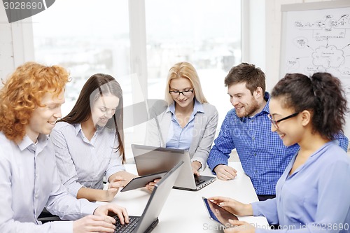 Image of smiling team with laptop and table pc computers