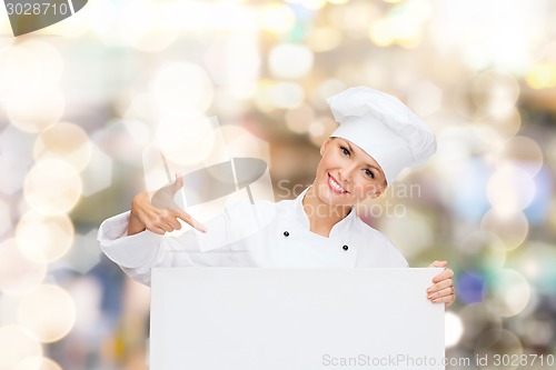 Image of smiling female chef with white blank board