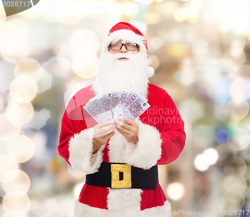 Image of man in costume of santa claus with euro money
