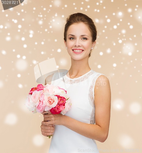 Image of smiling woman in white dress with flowers