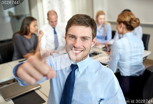 Image of group of smiling businesspeople meeting in office